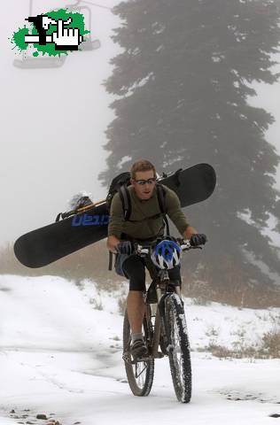 con el snowboard en la bici